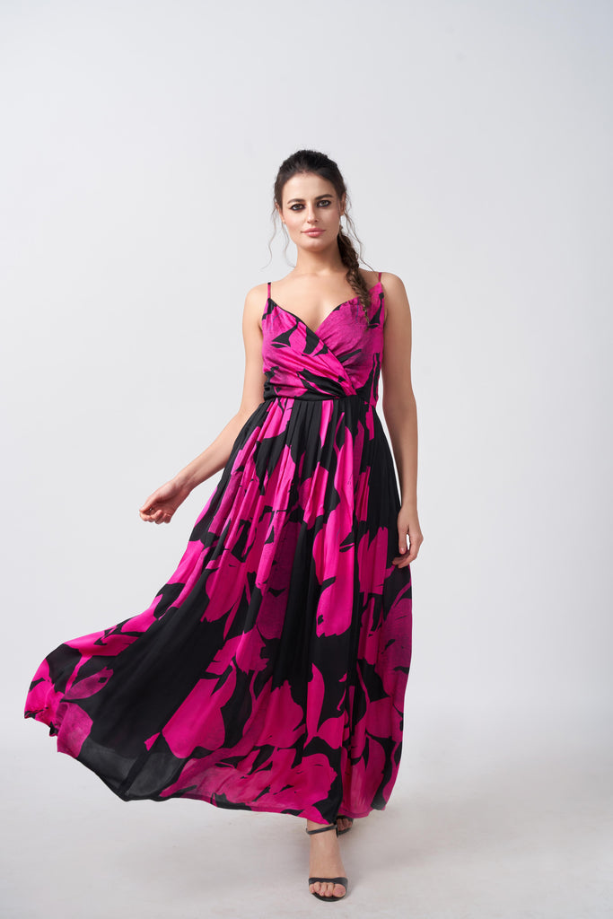 Model wearing an ankle-length satin dress with pink and black floral print, overlap neck, and spaghetti straps.