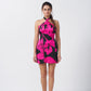 Model facing front in pink and black floral satin short dress with halter neck.