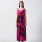 Model wearing ankle-length satin dress with pink and black floral print, front knot detail, and shoulder straps.
