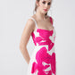 Close-up of the square neckline and shoulder strap detailing on the pink floral crepe midi dress.