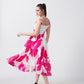 Model twirling in the pink and white floral crepe midi dress, showcasing its graceful flow and structure.