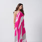 Side profile of model in pink, grey, and white abstract maxi dress, capturing the elegant drape and halter neckline.