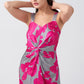 Close-up of twisted waist detail and wide straps on pink and grey floral satin maxi dress.