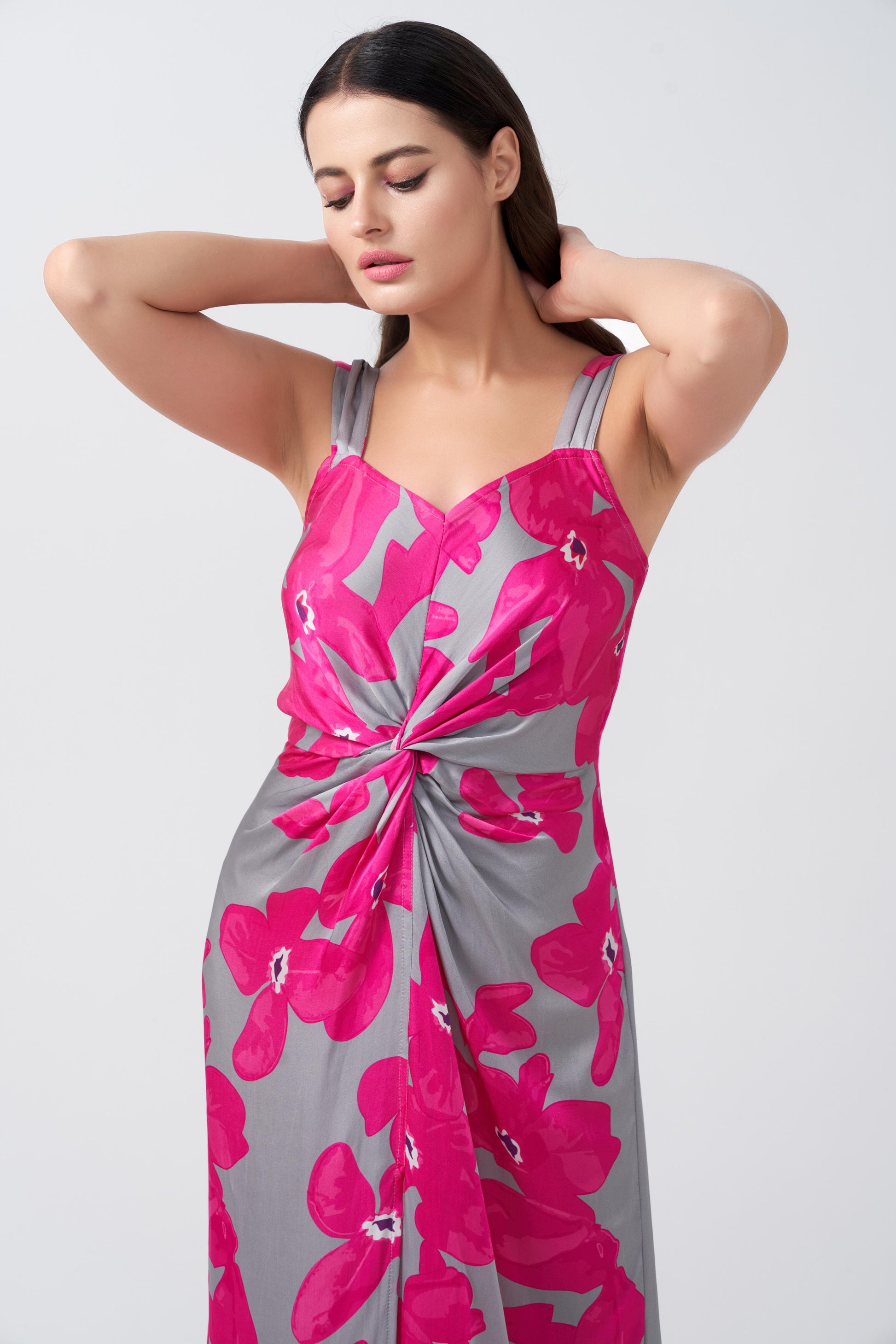 Close-up of twisted waist detail and wide straps on pink and grey floral satin maxi dress.