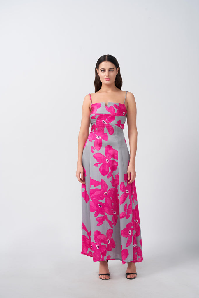 Model standing in a pink and grey floral satin maxi dress with spaghetti straps and square neckline.