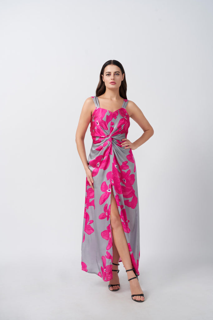 Front view of model in pink and grey floral satin maxi dress, featuring twisted waist and ankle-length hem.