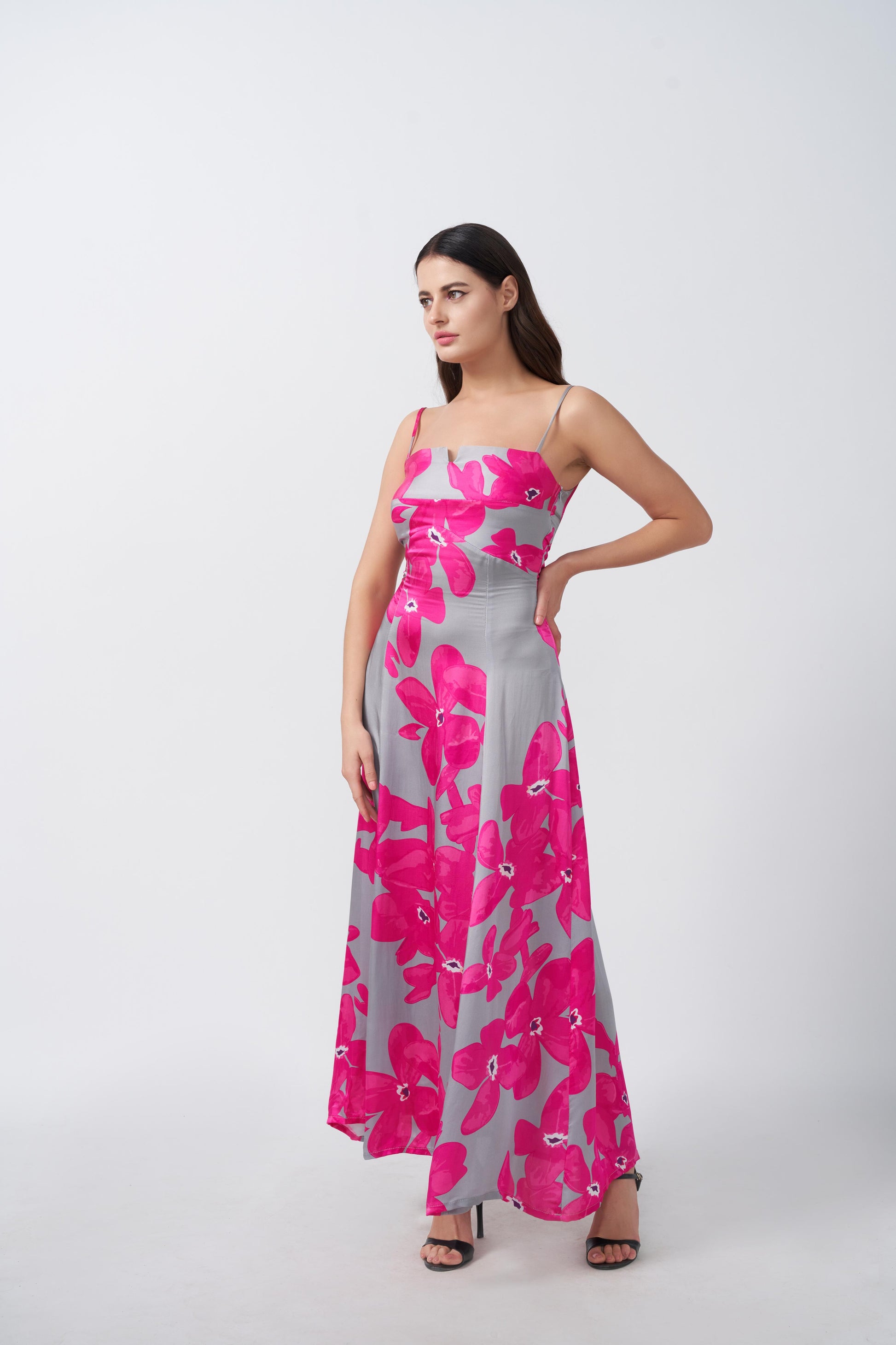 Model showing a side pose to highlight the flow and structure of the satin floral dress.