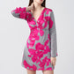 Close-up of model in pink and grey floral print satin dress with V-neck and bell sleeves, showcasing neckline detail.