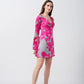 Model standing side-facing in the floral satin dress, highlighting the bell sleeves and overall fit.