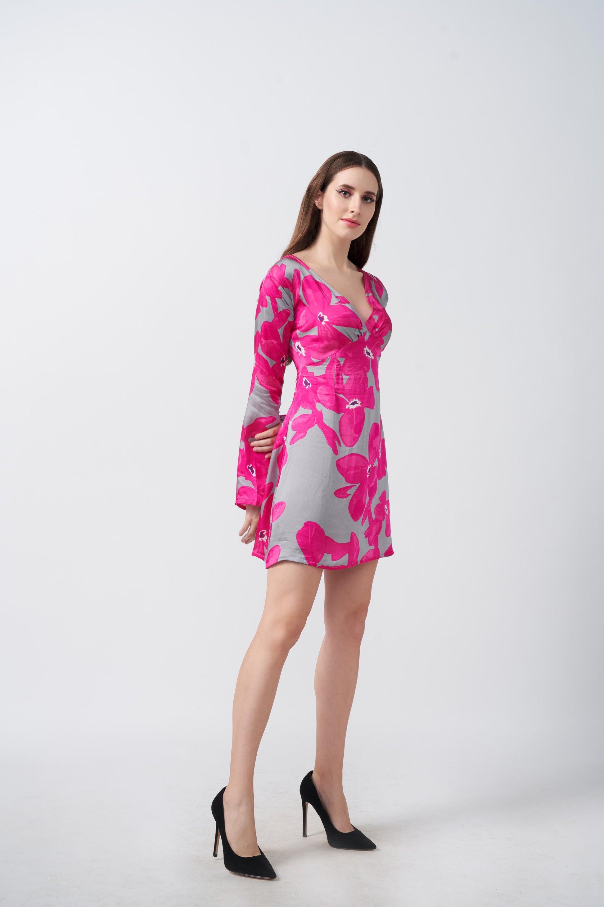 Model standing side-facing in the floral satin dress, highlighting the bell sleeves and overall fit.