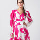 Close-up view of model highlighting the neckline and pleated sleeve details of the pink and white floral dress.