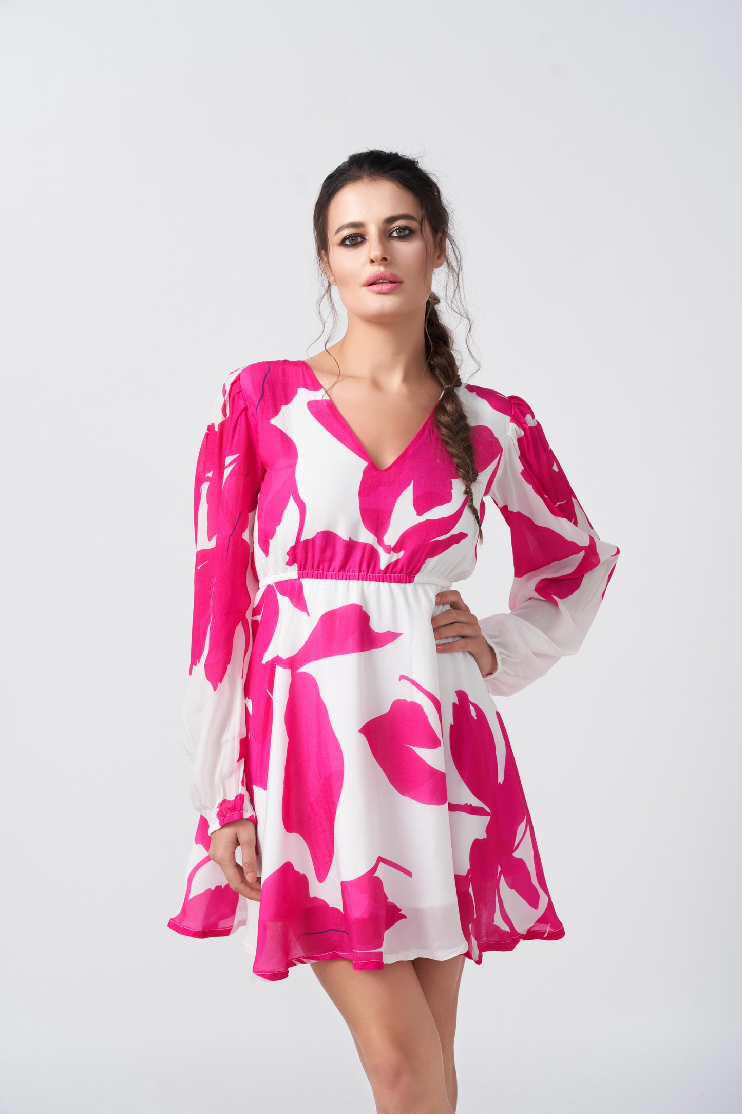 Close-up view of model highlighting the neckline and pleated sleeve details of the pink and white floral dress.