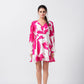Model standing front-facing in pink and white floral short dress with balloon sleeves and V-neckline.