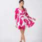 Walking pose of the model in pink and white V-neck dress, capturing the playful movement of the sleeves.
