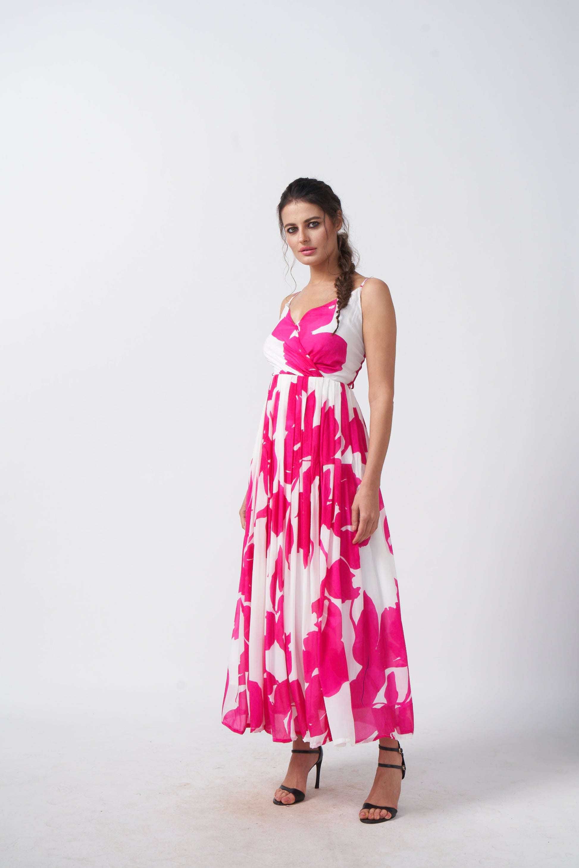 Model posing in a side-angle stance, highlighting the silhouette and flow of the pink and white floral crepe dress.