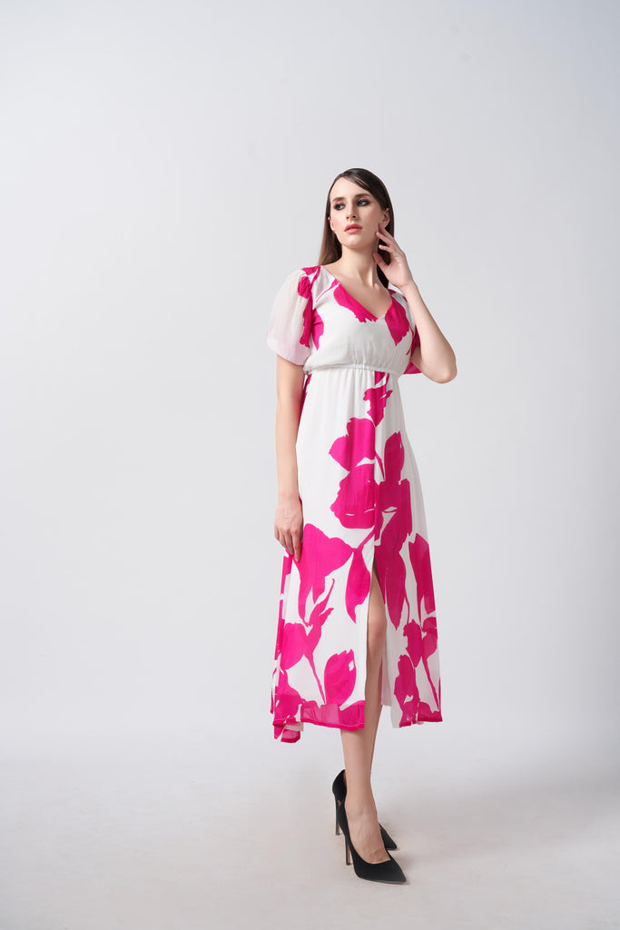 Model wearing a pink and white floral crepe midi dress with puff sleeves and V-neck, standing front-facing.