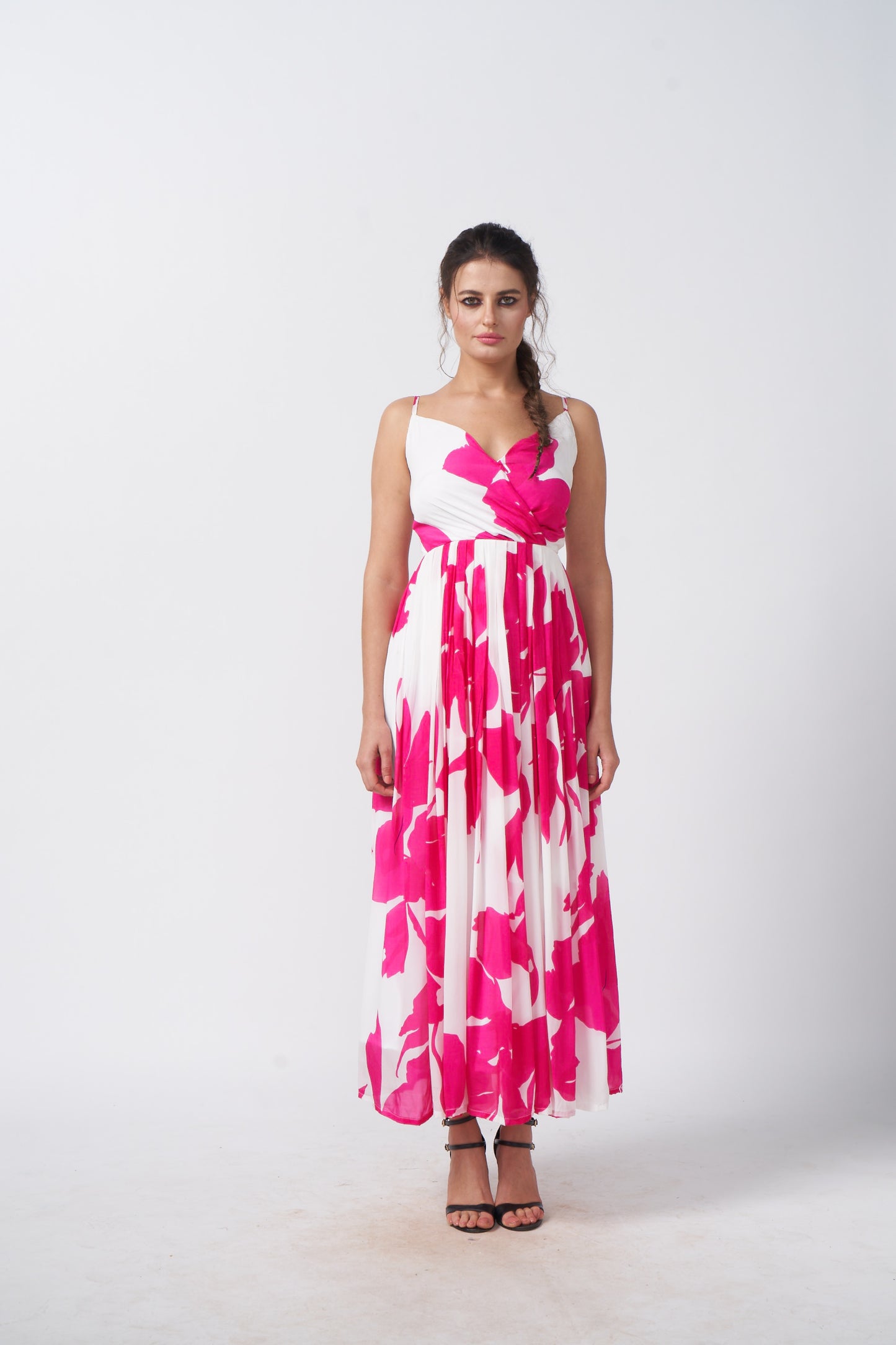 Model facing front in a pink and white floral ankle-length dress with spaghetti straps and gathered flare.