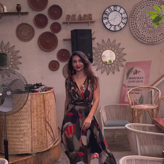 Model walking in bohemian halter maxi dress with flowing silhouette, front slit, and multicolor abstract pattern