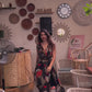 Model walking in bohemian halter maxi dress with flowing silhouette, front slit, and multicolor abstract pattern