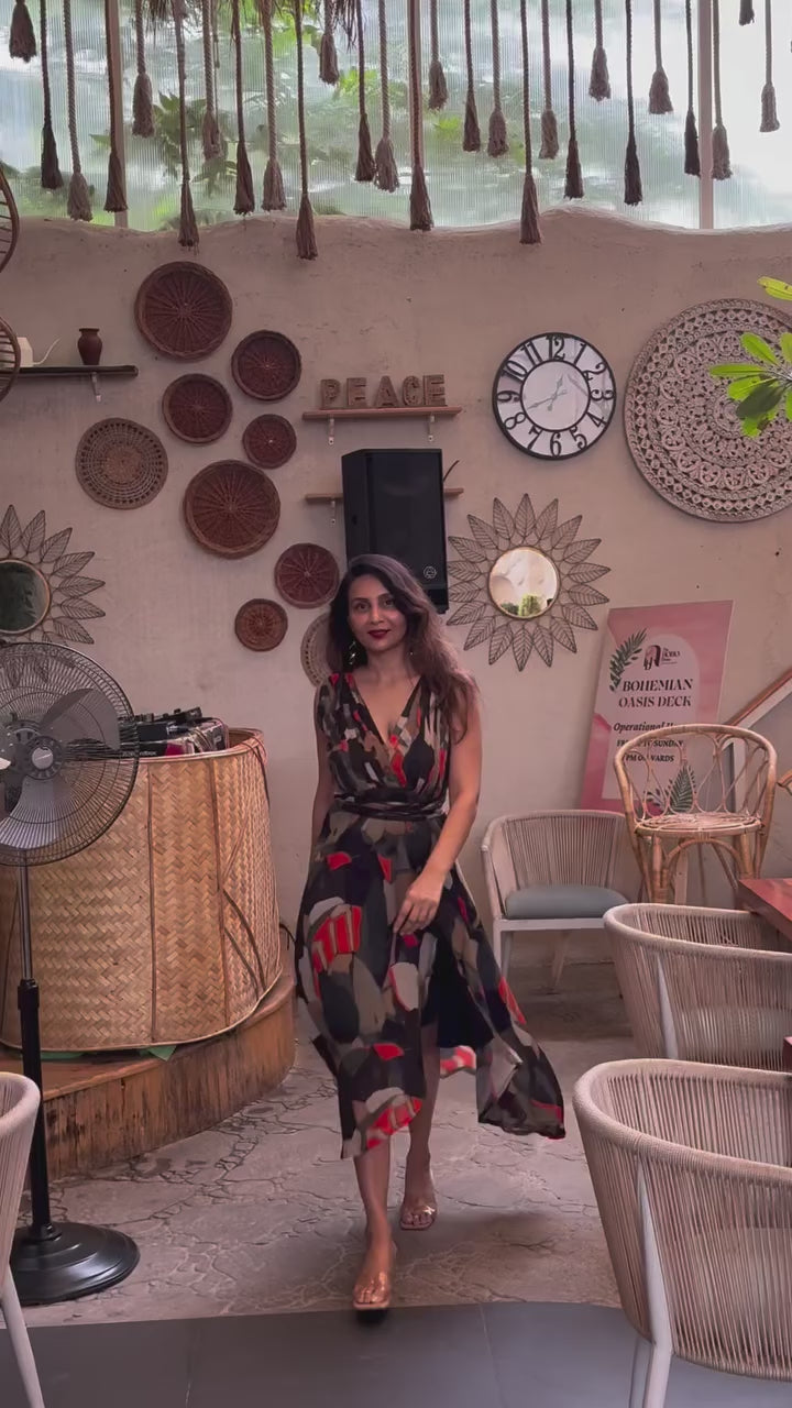 Model walking in bohemian halter maxi dress with flowing silhouette, front slit, and multicolor abstract pattern