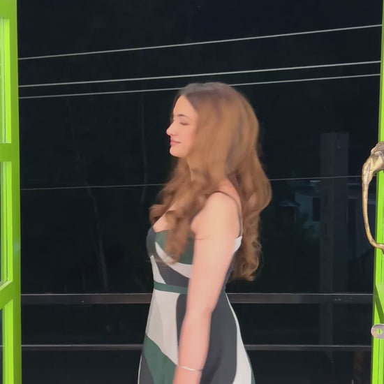 Video of the model in the abstract print midi dress walking outdoors at night.