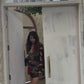 Model walking in boho-inspired chinon mini dress with deep V-neck, billowing sleeves, and multicolor abstract print