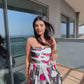 Video of a model walking outdoors in the abstract midi dress, showcasing waist cut details. 