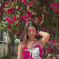 Video of a model outdoors near bougainvillaea, showcasing the vibrant print and flow of the gathered flare.