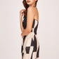 Side profile of the model in printed mini dress, showing cut-out detailing and tie-back neckline from an angle.