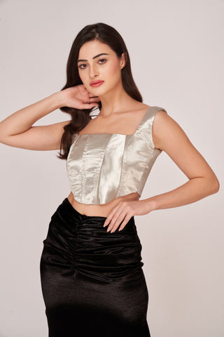 Close-up detailing the textured metallic finish of the corset and the flattering ruched waistline of the skirt, emphasizing the luxurious contrast of materials.