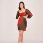 Angled view of model in green floral puff sleeve mini dress, both hands on hip showcasing square neckline and fit.