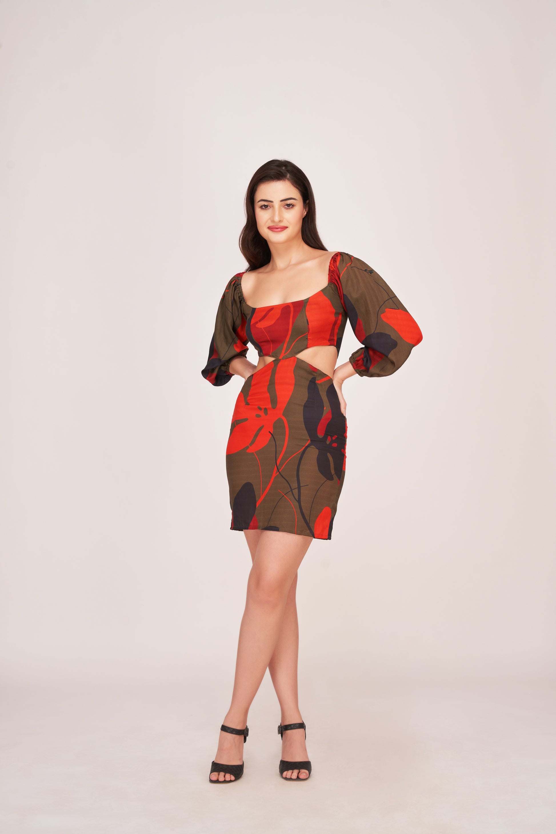Angled view of model in green floral puff sleeve mini dress, both hands on hip showcasing square neckline and fit.