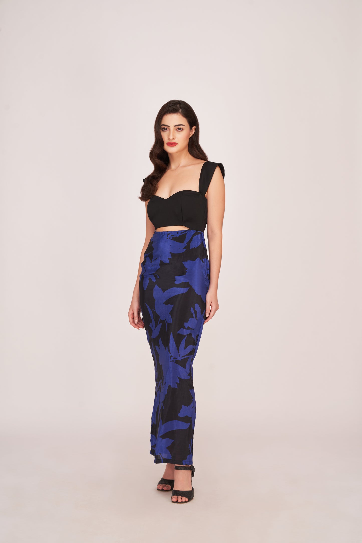 Model showcasing the flow and structure of the purple and black dress from a walking perspective.