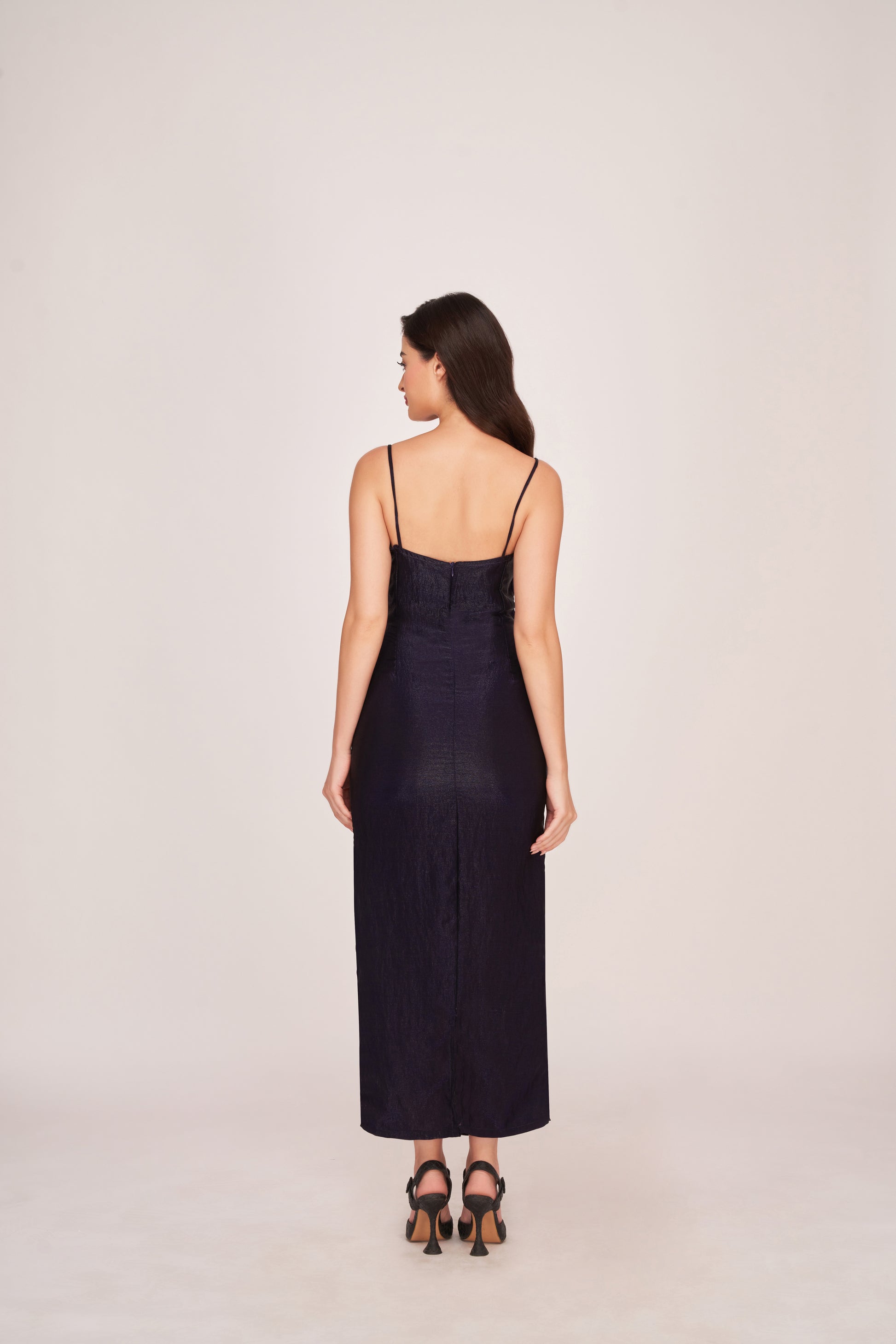 Rear view of the purple ruched dress showing full back profile, strap-shoulder design, and back zip closure.