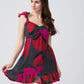 Side view of model posing outdoors in red and pink floral abstract dress with frill shoulder strap.