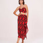 Model standing front-facing with hands on waist, wearing red printed crop top and abstract frill skirt.