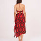 Rear view showing the open tie-back red crop top and the cascading frill detail of the abstract skirt.