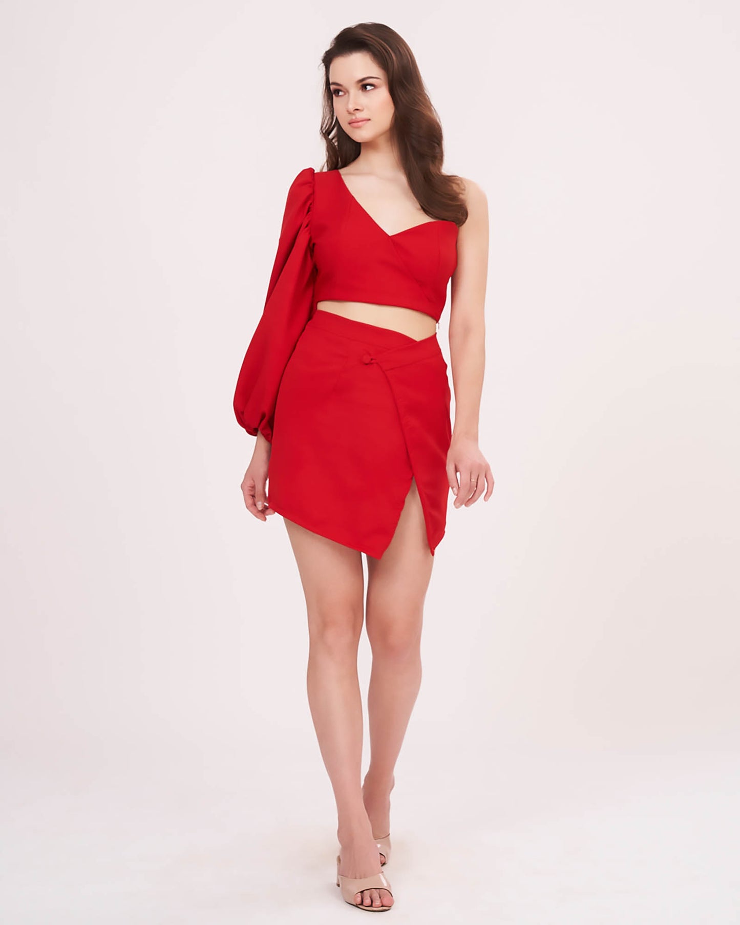 Full-length front pose showing the entire co-ord set, including the bold one-shoulder sleeve, flattering fit of the crop top, and rose-inspired mini skirt with front slit.