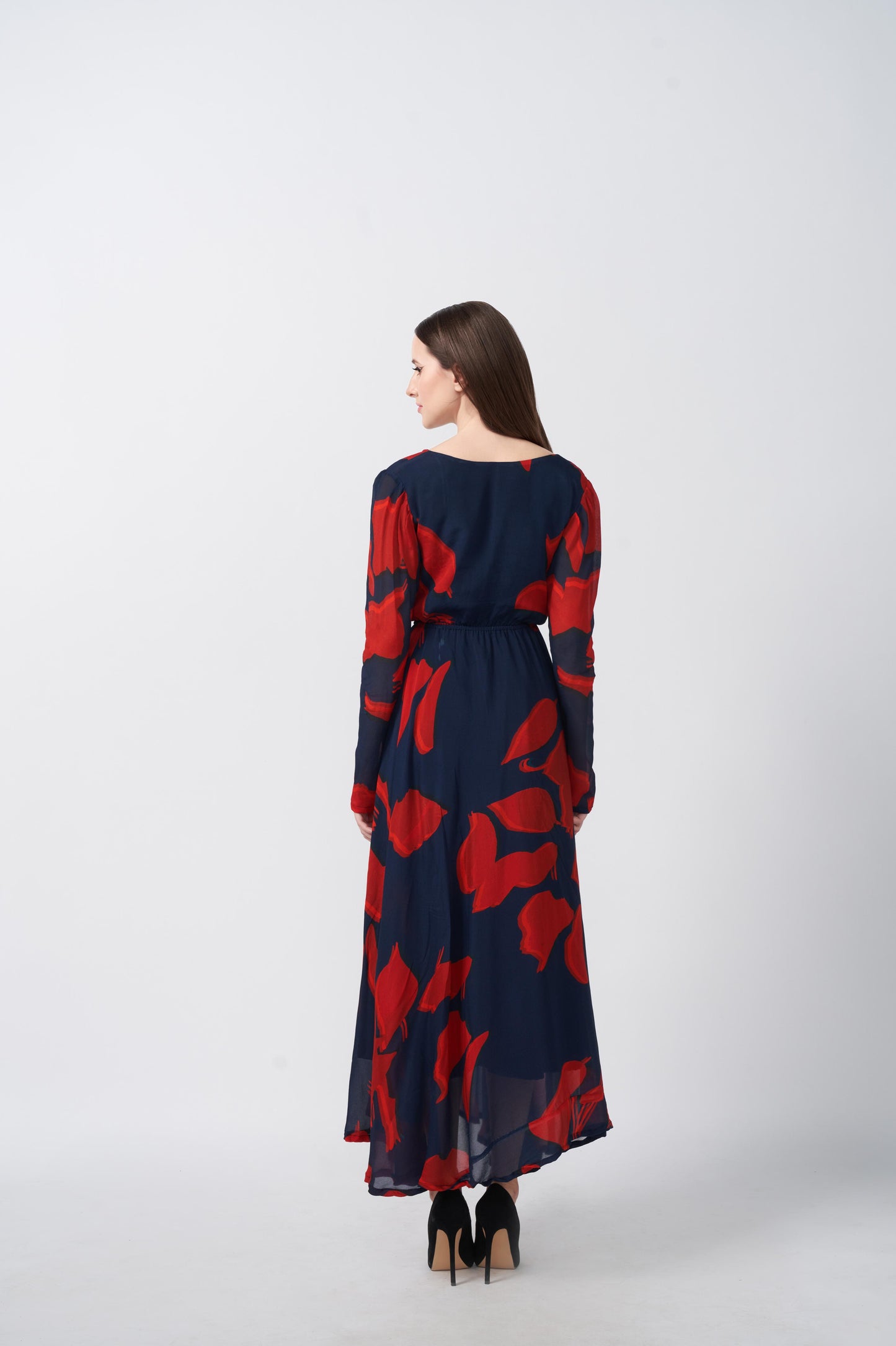 Rear view of red and navy abstract floral print dress showing the flowy back silhouette.