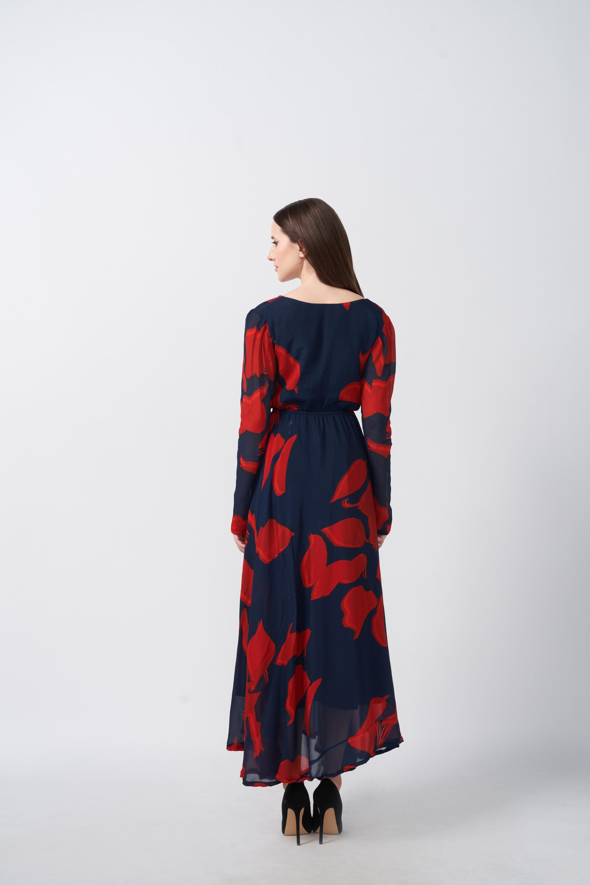 Rear view of red and navy abstract floral print dress showing the flowy back silhouette.
