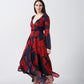 Full-length walking pose of model showcasing flow and slit of red and navy abstract dress.