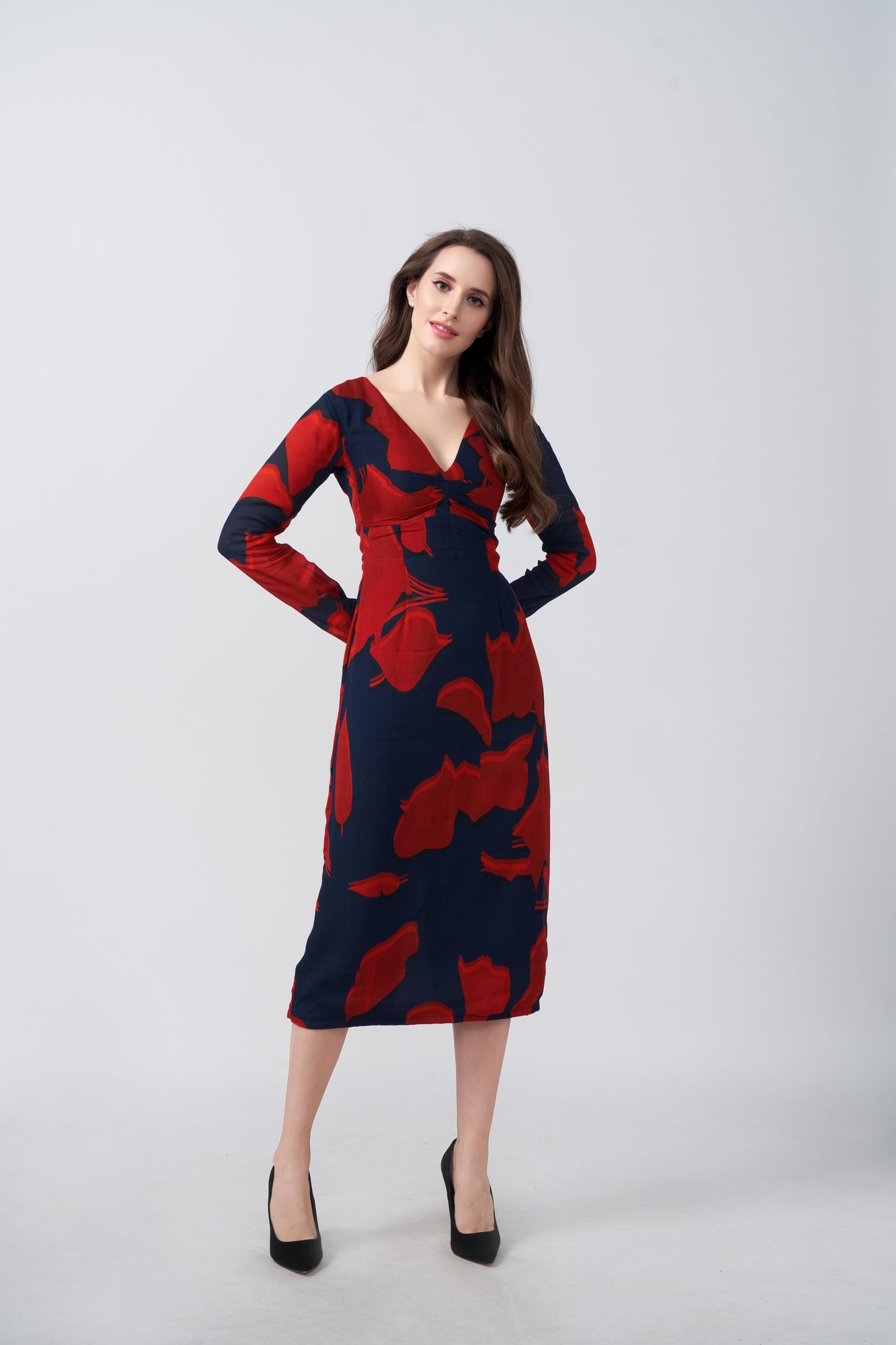 Midi-length dress featuring a bold abstract floral print in scarlet red against a deep navy blue background. The design showcases a flattering V-neckline and long, fitted sleeves. 