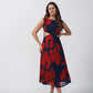 Model posing front-facing in a red and navy abstract floral sleeveless midi dress with waist cutouts.