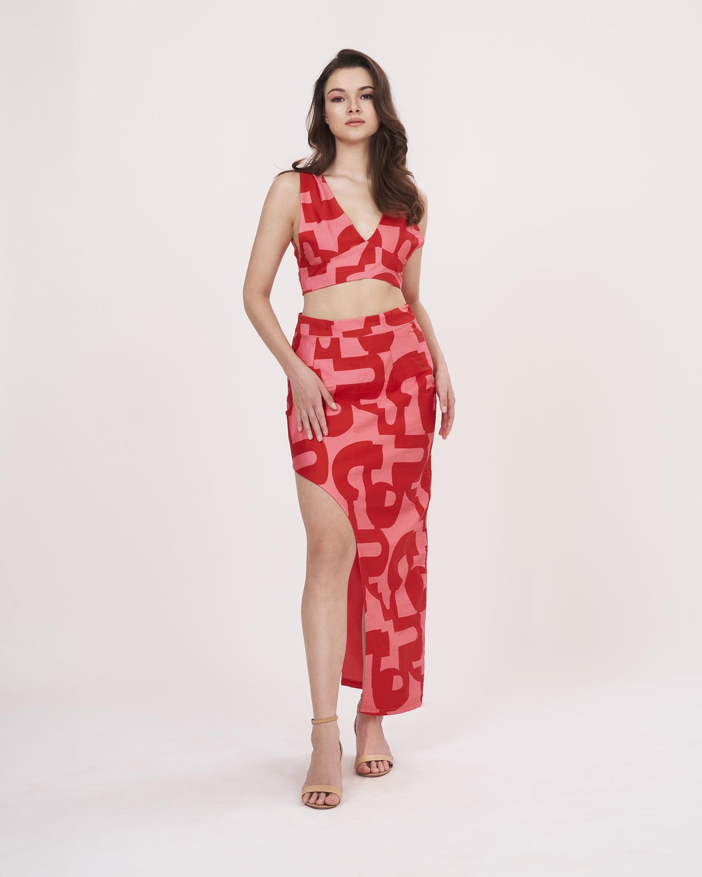 Full-length image showcasing the complete red co-ord outfit with printed geometric pattern and flowy high-slit skirt.