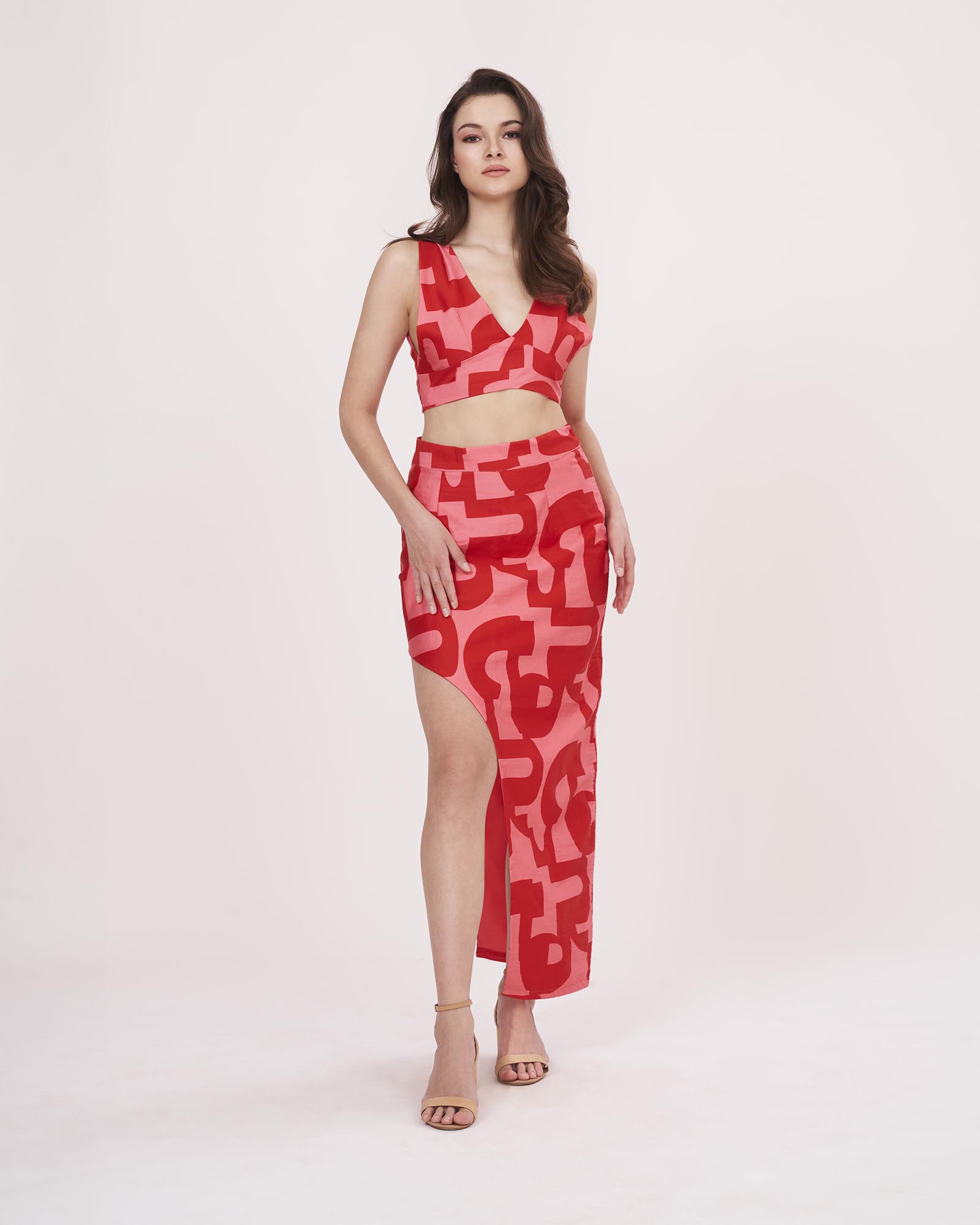 Full-length image showcasing the complete red co-ord outfit with printed geometric pattern and flowy high-slit skirt.