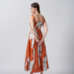 Back view of a burnt orange and white abstract print cotton satin midi dress with a flowing drape