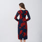 Back view of a red and navy abstract floral midi dress with long sleeves and a fluid drape