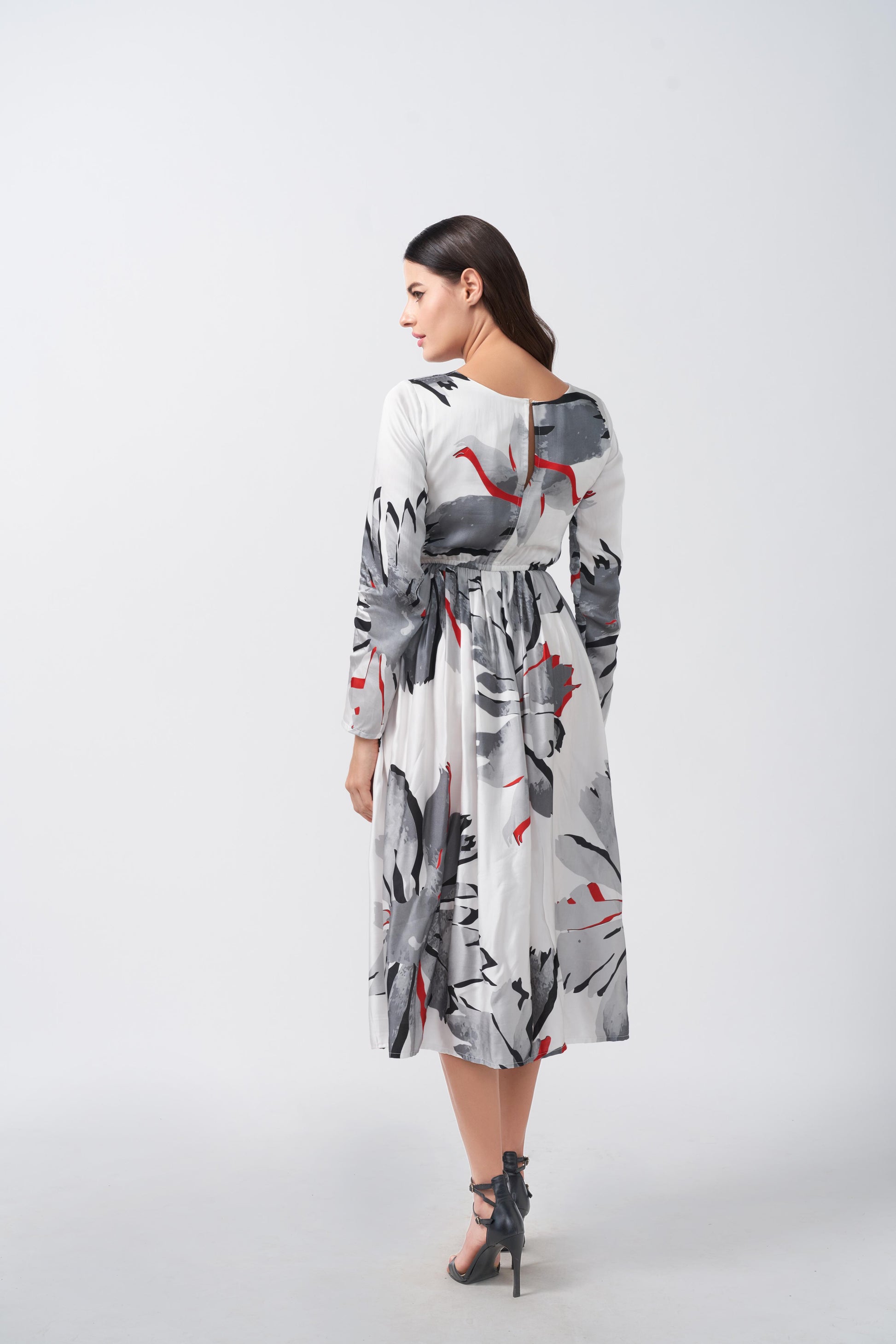 Back view of a satin midi dress with long sleeves and a flowing silhouette