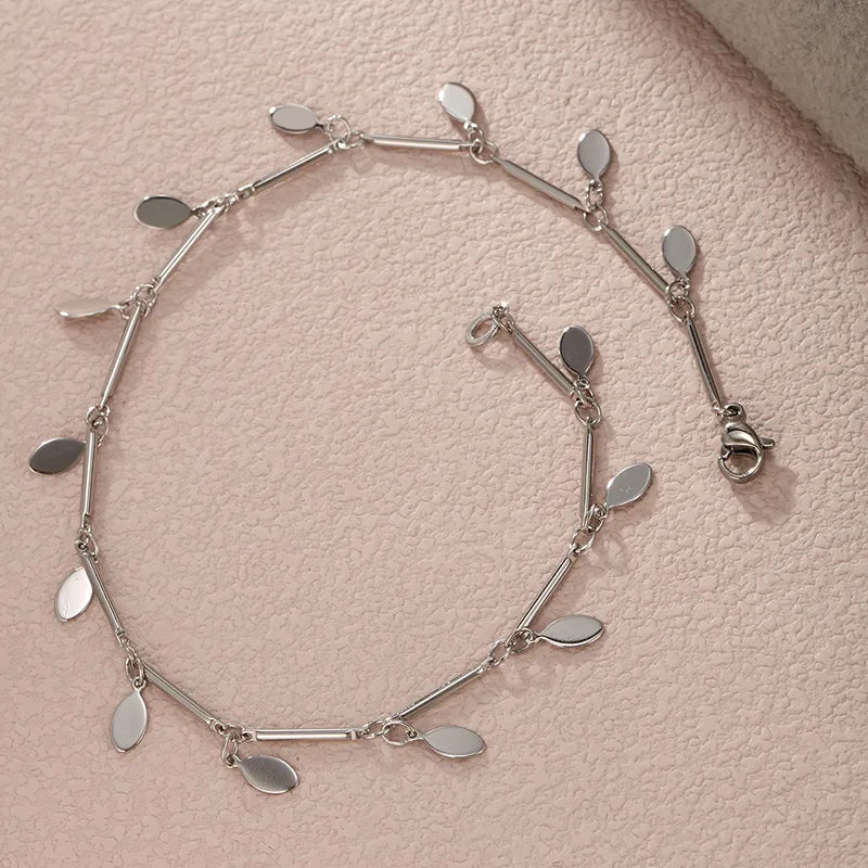This high-shine silver charm anklet offers a clean and modern aesthetic, designed to be a versatile staple that elevates both your professional office attire and your favorite holiday outfits.