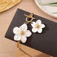 This elegant gold-toned anklet with its row of blooming white blossoms offers a timeless look, designed to elevate your summer vacation wardrobe or high-end resort wear.